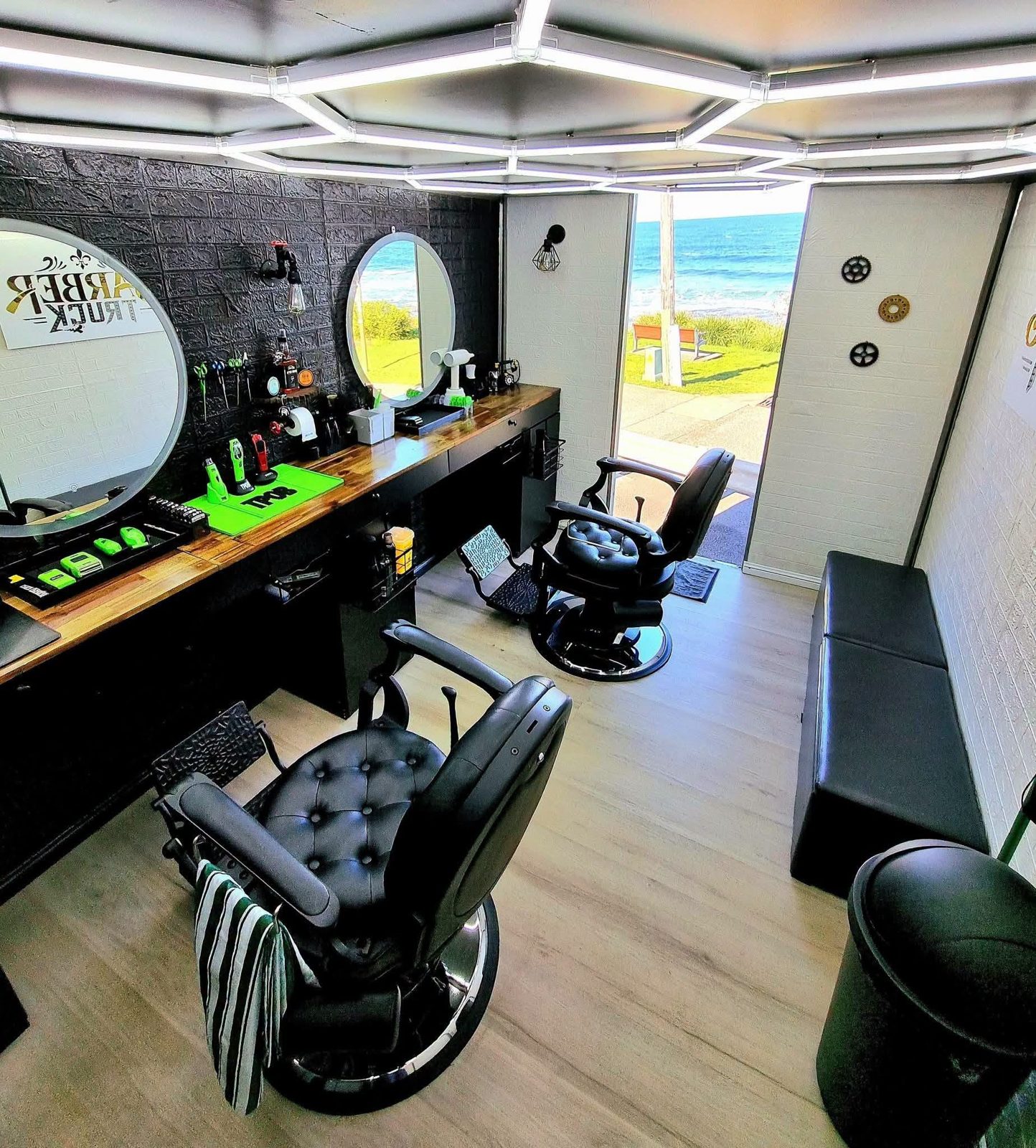 Inside the barber truck: leather chairs, mirrors and an ocean view